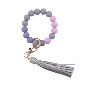 Silicone bead keychain with PU leather tassel and gold hardware detail for daily chic style.