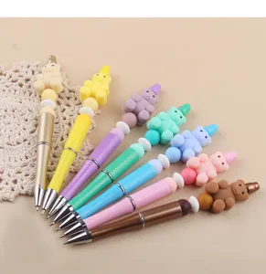 Creative DIY beaded pens with cute silicone bear charms, colorful plastic ballpoint pens.