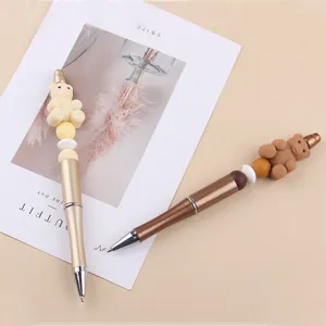 DIY beaded ballpoint pen with cute silicone bear charm and metallic barrel for creative gifts.