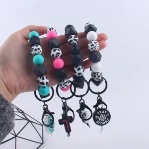 Silicone beaded wrist keychains with cow print and cute charms, perfect keyring accessory.