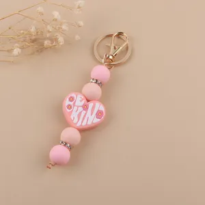 Portachiavi con perline in silicone rosa e ciondolo a cuore, distanziatori strass e moschettone.