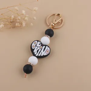 Portachiavi in perline di silicone con perle sferiche in bianco e nero e ciondolo a cuore.