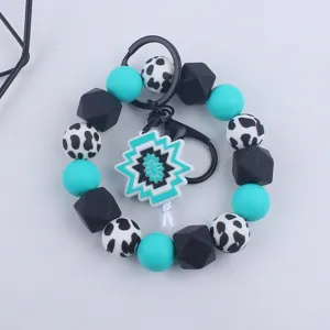 Silicone beaded wristlet keychain with cow print beads and geometric pendant for daily use.