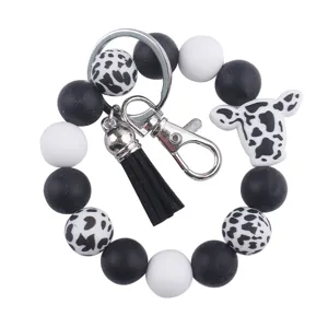 Llavero de pulsera con cuentas de silicona de vaca, borla de cuero PU negro y cierre metálico.
