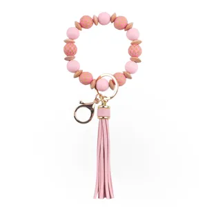 Detalle llavero cuentas silicona madera rosa con borla de PU y accesorios metal dorado.