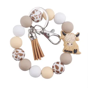 Llavero de cuentas de silicona con diseño de vaca de dibujos animados y borla de cuero elegante