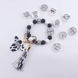 Cow print silicone bead keychain bracelet with cow head pendant, tassel and text round inserts.