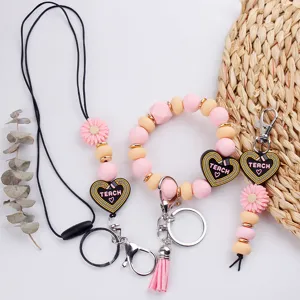 Ensemble porte-clés lanière bracelet en perles de silicone avec marguerites et pendentifs cœur.