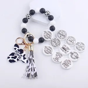 Cow print silicone bead wristlet keychain with leather tassel and funny quote charms.