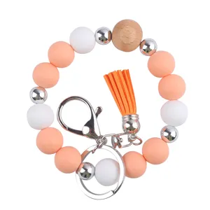 Silicone beaded bracelet keychain wristlet with wood bead and cute PU leather tassel detail.