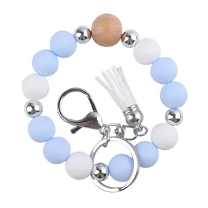 Silicone beaded wristlet keychain featuring wooden and metal beads with a white PU leather tassel.