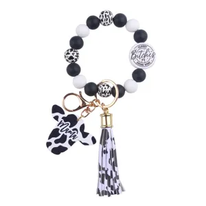 Silicone bead wristlet keychain with cute cow head pendant, leather tassel and round printed badge.