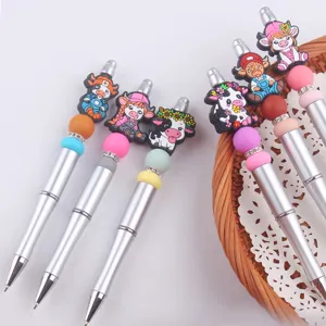 Penna a sfera fai da te con simpatici ciondoli in silicone a forma di mucca e perline colorate.
