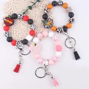 Silicone beaded keychain detail view, featuring teacher apple charm and colorful cute tassel design.
