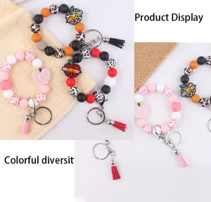 Silicone beaded wristlet keychain with cute apple charm and tassel, colorful DIY fashion keyring accessory.