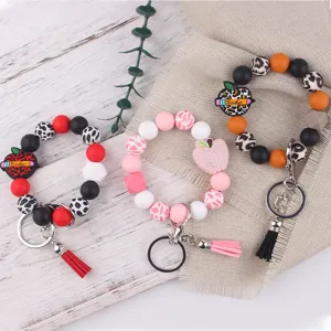Silicone beaded wristlet keychain with cute apple charm and tassel for daily use.