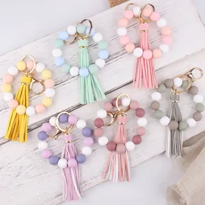 Detail view of colorful silicone bead keychains with leather tassels, ideal for wristlets.