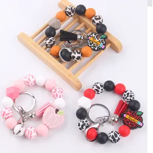 Silicone beaded wristlet keychain with PU leather tassel and teacher apple charms.