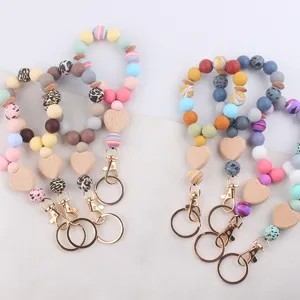 Colorful silicone beaded wristlet keychains with wooden heart charms and metal clasps.