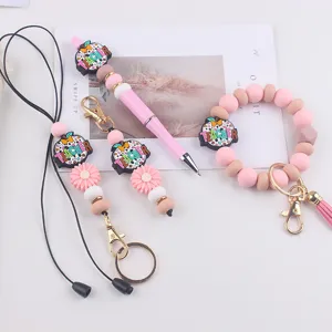 Simpatico set portachiavi in silicone a tema insegnante con penna, cordino e braccialetto.