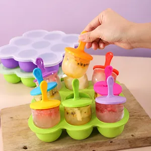 Nahaufnahme einer Hand, die ein Eis aus einer bunten 7-Loch-Silikonform für Kinder nimmt