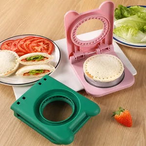Creative pink and green bear-shaped sandwich cutter and sealer tool shown on a wooden table
