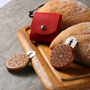 Close-up of wooden bread lame tools with intricate engraving and red leather case