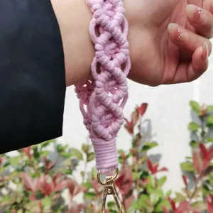 Cordón de muñeca rosa de macramé hecho a mano llavero detalle de primer plano patrón tejido.