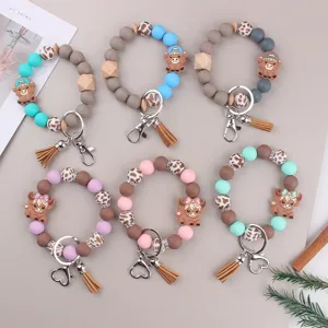 Cartoon highland cow silicone beaded keychain bracelet detail view with cute charms and tassels.