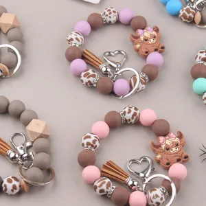 Cute silicone bead keychain bracelet with cartoon animal pendant and leather tassel design.
