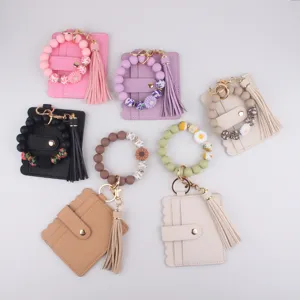 Silicone beaded bracelet card wallet detail view, colorful tassel keychain accessory close up.