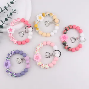 Silicone bead keychain bracelet detail view, colorful floral charm with heart clasp