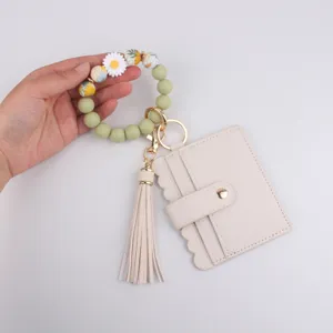 Close-up detail view of silicone beaded wristlet keychain with leather card holder tassel.
