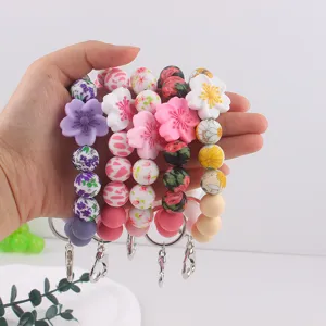 Colorful silicone bead keychain bracelet with cute flower charms for women and girls daily use.