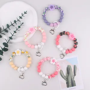 Silicone beaded keychain bracelet with cute flower charms and metal heart clasp.