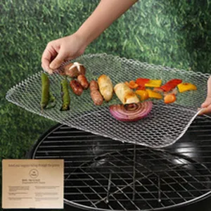 Detalle de bandeja de barbacoa de acero inoxidable con verduras y salchichas.