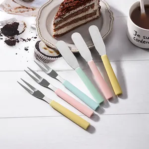 Detalle de cuchillos para mantequilla y tenedores de postre con mangos de colores pastel.