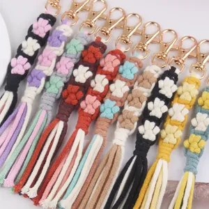 Detailed close-up of handmade woven cotton paw flower keychain strap with gold metal lobster clasp.