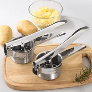 Detail view of manual stainless steel potato ricers on wooden board for kitchen use