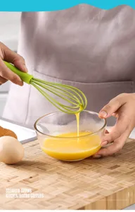 Nahaufnahme des Mini-Silikon-Schneebesens in der Küche beim Schlagen von Eiern.