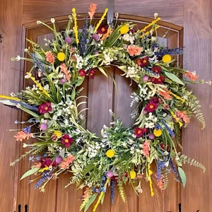 Detailed close-up of colorful artificial floral wreath with vibrant seasonal blooms on rustic door.