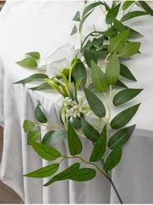 Detailaufnahme künstliche grüne Rebe mit weißer Rose und Blättern für die Heimdekoration.