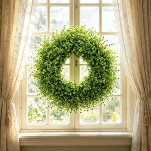 Gedetailleerd overzicht van kunstmatige buxuskrans hangend aan het raam voor deco.