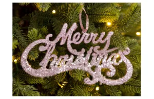 Detailaufnahme des glitzernden pinken Merry Christmas Hängeschilds am festlichen Weihnachtsbaum.