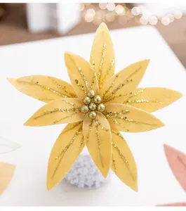 Nahaufnahme der goldenen Samt-Weihnachtsblume mit glitzernden Pailletten für festliche Deko.