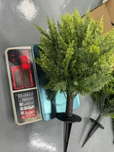 Artificial green plant ground plug tree detail view, spring garden decoration outdoor plant.