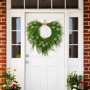 Detail shot of artificial pine and eucalyptus wreath hanging on door for home decor.