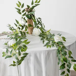 Künstliche grüne Pflanze Rebe mit Olivenblättern und weißen Rosen für Tischdeko und Hochzeit.