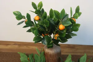 Pianta artificiale in vaso con foglie di limone, dettaglio ideale per decorare la casa.