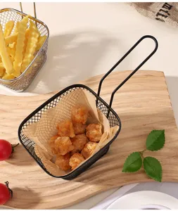 Detail view of mini metal french fry baskets with fried chicken and food paper on wood tray.